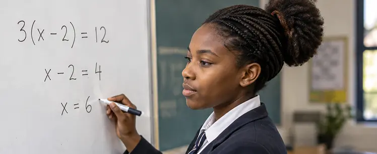 A learner solving an algebra equation on a classroom whiteboard
